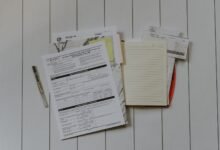 A flat lay of stacked paper documents on a desk, ready to be organised for research