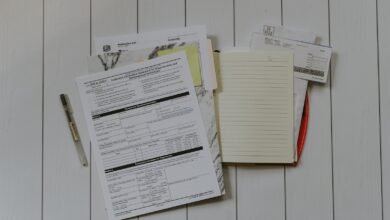 A flat lay of stacked paper documents on a desk, ready to be organised for research