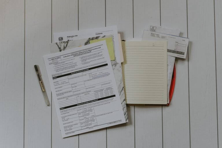 A flat lay of stacked paper documents on a desk, ready to be organised for research